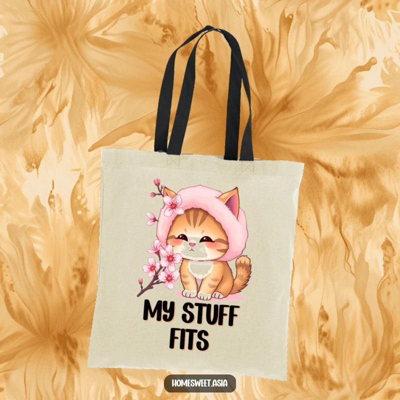 Funny tote bag featuring a cat wearing a furry hat, curiously smelling a vibrant cherry blossom flower.